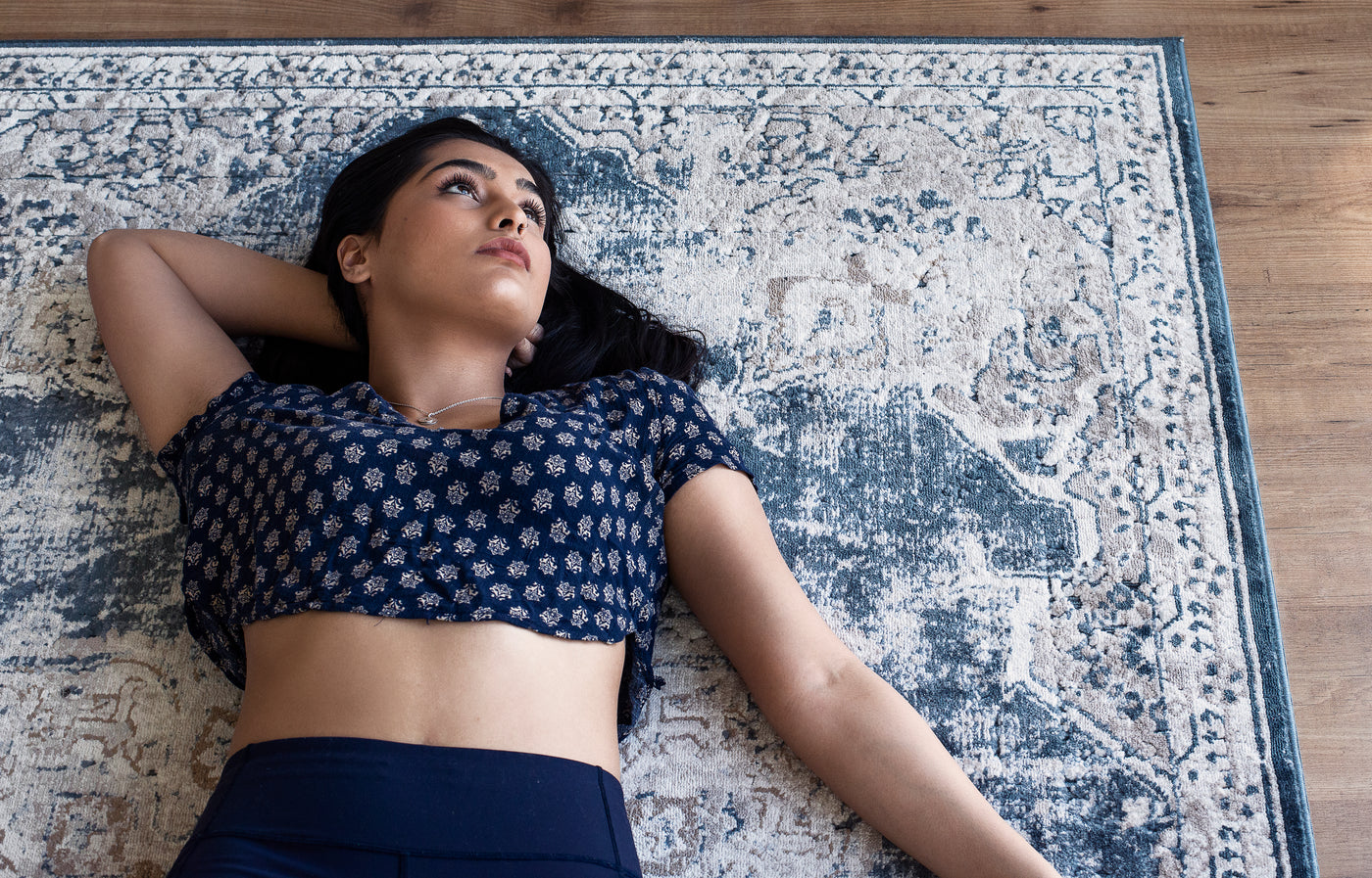 woman laying down on blue rug